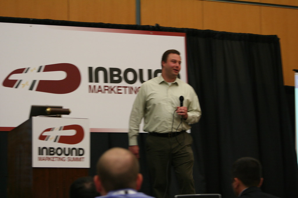 Speaker with a microphone presenting on stage at an Inbound Marketing Summit